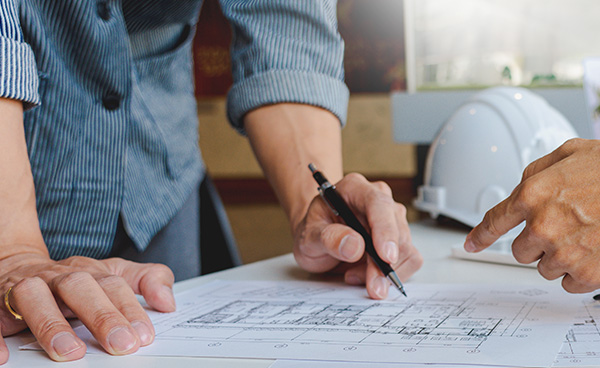 Fachplanung Baubegleitung Neubau Sanierung, zwei Männer stehen an einem Tisch und beraten über Baupläne