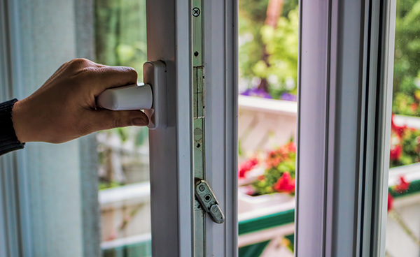 Lüftungskonzept, eine Hand öffnet ein Doppelverglastes Fenster